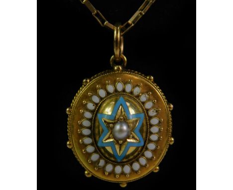 A Victorian Etruscan style oval hair locket pendant, set with a central seed pearl, within a blue enamel star, within a white