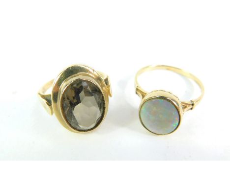 A smokey quartz ring, size P/Q, set in yellow metal, and a 9ct gold and opal ring, size T, 8.6g. (2)