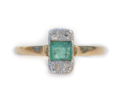 An 18ct gold emerald and diamond Art Deco dress ring, the central ash cut emerald set in platinum, with four tiny diamonds il