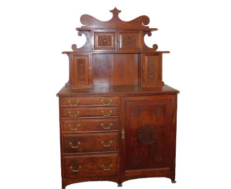 An early 20thC oak sideboard, dated 1916, the shaped back with four carved panelled doors and shelves, over five graduated dr