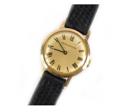 A Jaeger-LeCoultre lady's 9ct gold circular cased wristwatch, champagne dial bearing Roman numerals, on a leather strap.