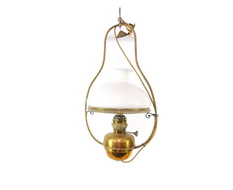 An early 20thC brass hanging oil lamp, with a white glass shade, 71cm H.