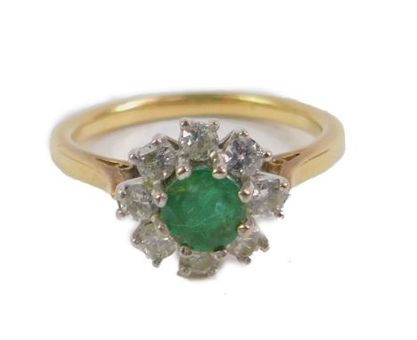 An emerald and diamond flower head ring, set  in yellow metal, diamonds approx 1/4ct, size K.