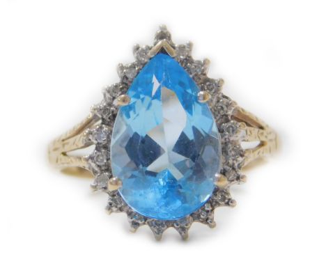 A 9ct gold aquamarine and diamond ring, the pear shaped aquamarine surrounded by tiny diamonds, with pierced fan design shoul