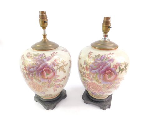 A pair of Chinese pottery table lamps, enamel decorated with flowers, raised on a square canted wooden base, 37cm H.