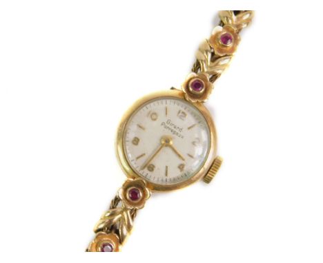 A Girard Perregaux lady's 9ct gold wristwatch, circular dial bearing Arabic numerals and batons, on a ruby set floral bracele