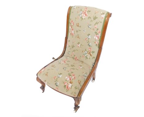 A Victorian walnut reclining nursing chair, with lever action recliner, upholstered in rose floral fabric, raised on cabriole