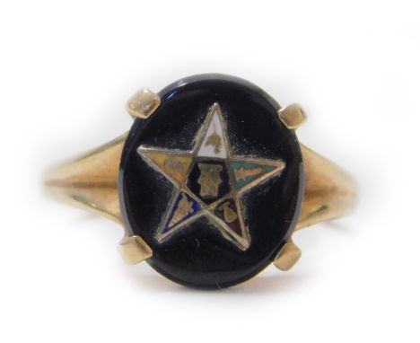 A Romany Masonic black onyx ring, with oval black agate stone centre, with raised gold star motif of varying enamel colour an