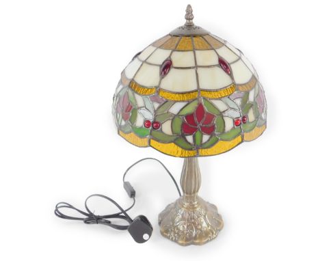 *A Tiffany style table lamp with floral and jeweled decorated shade, raised on a leaf molded faux metal base,  48cm H, 29cm D