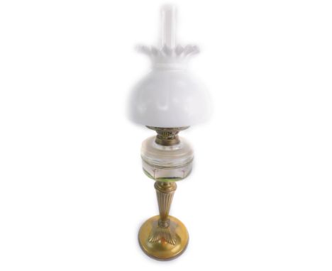An early 20thC Duplex brass oil lamp, with a frosted glass reservoir painted with autumn trees, with chimney and white frille