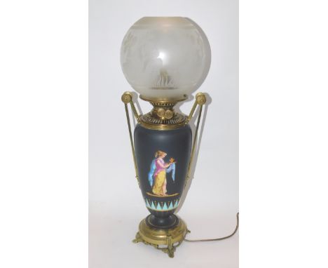A French late 19thC porcelain and brass oil lamp, of twin handled Romanesque form, decorated with figures against a black gro