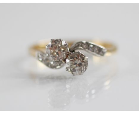 An early 20th century diamond toi et moi diamond ring, comprising two round old cut diamonds, measuring 4.61mm x 2.96mm and 4