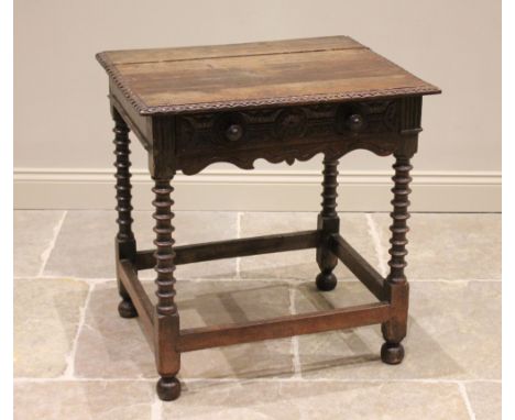 An 18th century and later oak side table, the rectangular plank top with carved detail to the edge, over a single carved frie