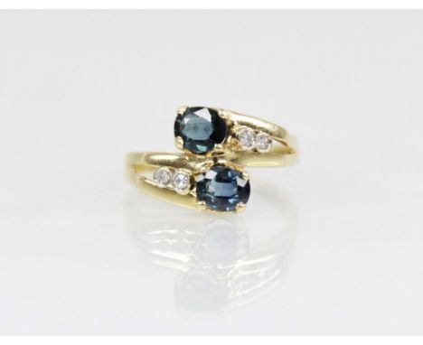 A continental sapphire and diamond 18ct gold crossover ring, designed as two oval mixed cut sapphires, each measuring 5.3mm x