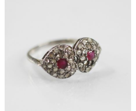 A diamond and ruby ring, designed as two hearts, each with a mixed cut ruby to centre with a surround of single cut diamonds,