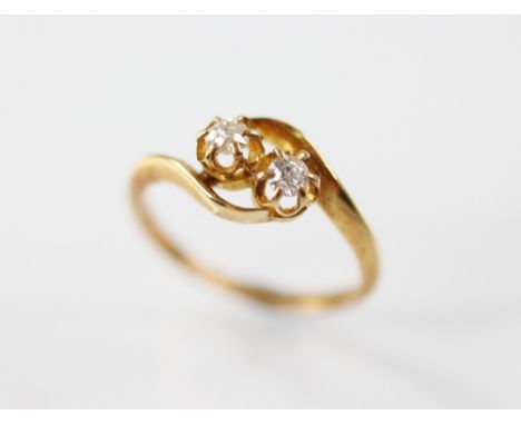 An Edwardian diamond 'moi-et-toi' ring, designed as two round old cut diamonds, claw set in 18ct gold to twist design shoulde