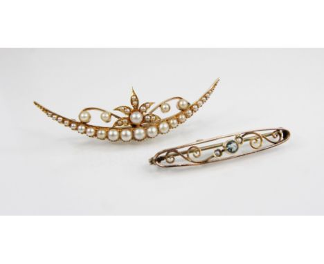 A Victorian gold coloured pearl set brooch, modelled as a crescent moon surmounted by a scrolling foliate motif, set with gra