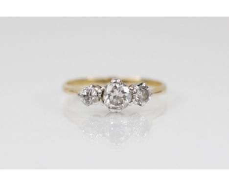 An early 20th century three stone diamond ring, the central round cut diamond measuring 4.57mm W x 2.84mm D, with a further r