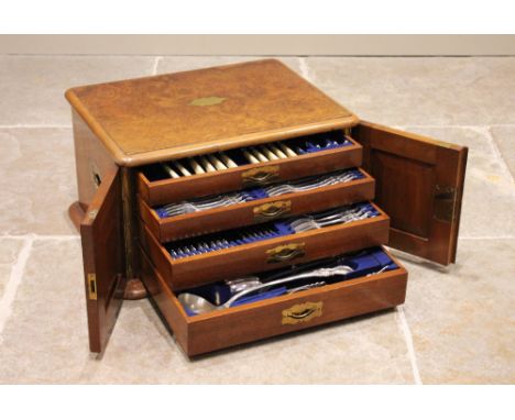 A late Victorian burr walnut canteen of cutlery, the rectangular moulded top above a pair of panelled doors opening to four g