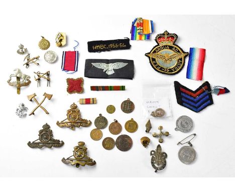 A collection of military badges and buttons, to include Royal Army Service Corps and Royal Artillery examples, fabric badges 