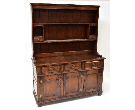 A Georgian-style oak dresser with boarded plate rack incorporating two spice shelves, above a base of three short drawers, ab