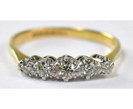 An 18ct gold ring set with five white gold claw set graduated diamonds, stamped '18', size P, approx. 2.7g.
