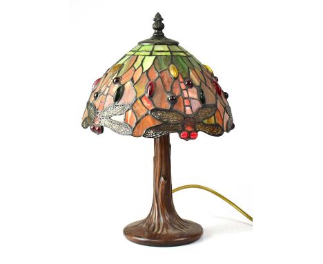 A small Tiffany-style table lamp with leaded stained glass shade, with dragonflies, raised on a bark-effect resin base, heigh