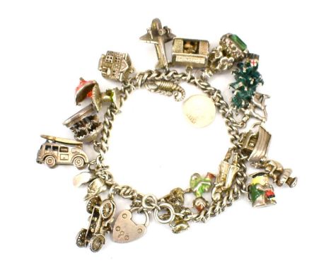 A silver charm bracelet with seventeen charms to include fire engine, house, aeroplane, seal, Toby jugs etc, approx. 2.2ozt.