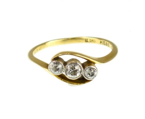 An 18ct gold three-stone diamond ring, the three small bezel set brilliant cut diamonds in a crossover setting, size P, appro