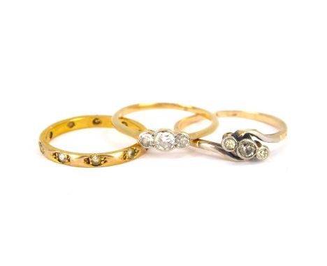 Three 9ct gold rings comprising a crossover ring with three graduated bevel set diamonds, size Q, a ring set with three gradu