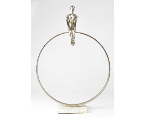 A contemporary silvered sculpture of a figure sitting on a large hoop and raised on square marble plinth, unsigned, height 54