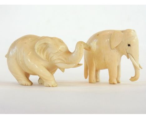 Carved ivory model of an elephant with twisted trunk, 10cm high and another (2) 