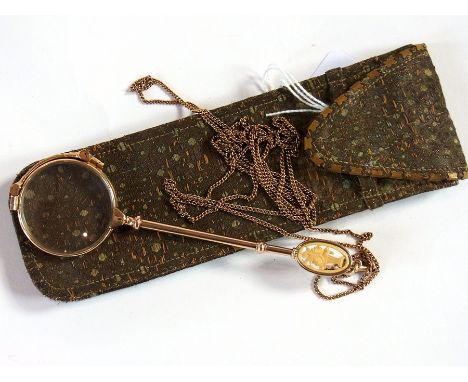 Early 20th century gold coloured metal lorgnette, marked 14k, sprung release mechanism to handle and carved ivory terminal of