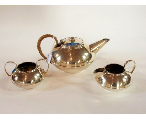 A silver plate teapot of compressed form with a matching sugar basin and a small milk jug 