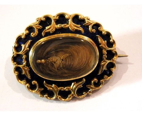 Victorian gold-coloured metal and blue enamel mourning brooch of shaped oval form, the blue enamel overlaid with gold-coloure