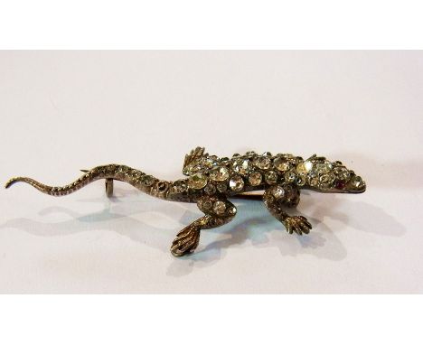 Silver brooch of a lizard inset with white stones and coloured ruby eyes 