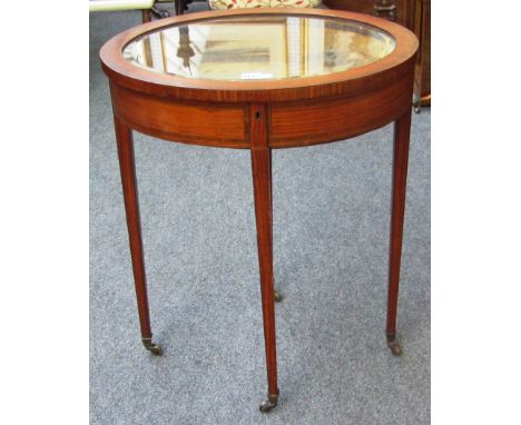 An Edwardian inlaid mahogany oval vertu table on tapering square supports, 57cm wide.