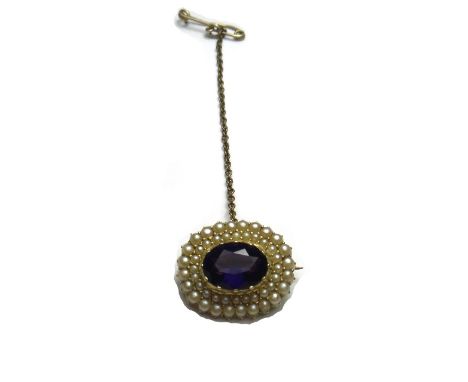 A gold, amethyst and seed pearl set oval brooch, mounted with the oval cut amethyst at the centre, within a twin surround of 