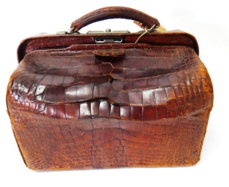 A late Victorian silver mounted travelling case, formed as a crocodile Gladstone bag, the interior with a variety of silver m