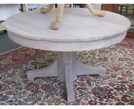 A 19th century limed oak circular table on four downswept supports, 123cm wide. 