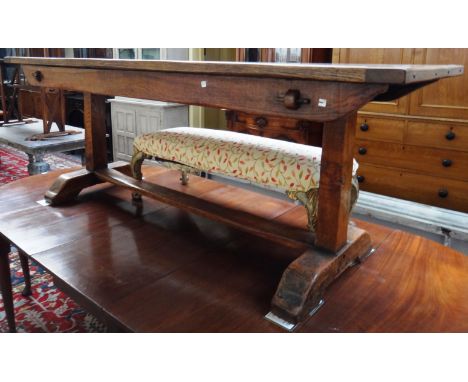 A 17th century style oak refectory table on trestle end standards, 70cm x 197cm.