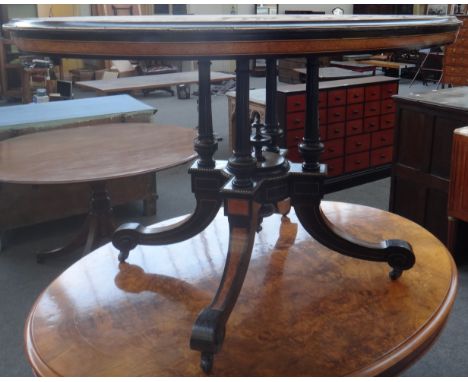 A late Victorian gilt metal mounted amboyna ebonised oval breakfast table on four downswept supports, 89cm wide x 122cm. 