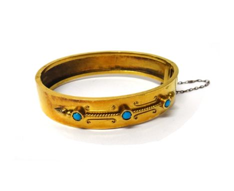 A Victorian gold and turquoise set three stone oval hinged bangle, the front with applied decoration in the classical taste, 