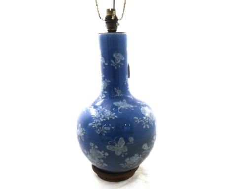 A Chinese blue-ground bottle vase, 19th century, painted in white with insects and flowers, 26cm.high., adapted as a lamp wit