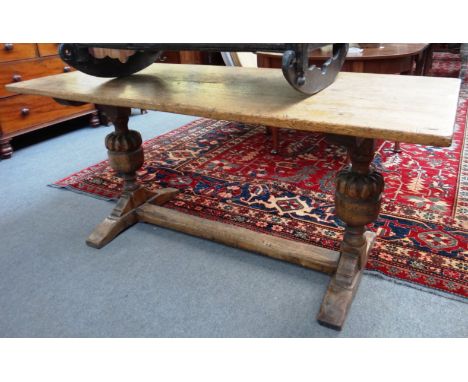 A 17th century style oak refectory table on cup and cover supports, 69cm x 168cm. 