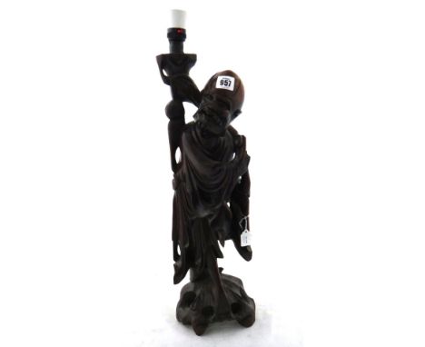 A Chinese hardwood carving of a sage, 20th century, standing on a pierced mound base, 54cm.high, adapted as a lamp, and an In