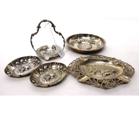 A German ashtray, of circular form, decorated with a tavern scene, within a cast scrolling border and fitted with a carrying 