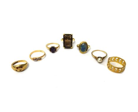 A gold ring, claw set with a rectangular cut smoky quartz, a gold band ring, with pierced decoration, bears Oriental characte