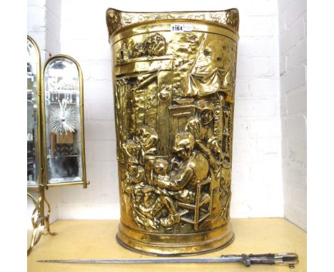 A brass coal bin, 20th century, modelled as a harvesting hopper and cast in high relief with an interior scene (73cm high) wi