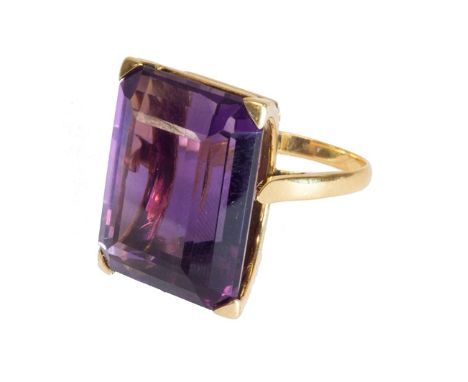 A gold and amethyst set single stone ring, claw set with a large cut cornered rectangular step cut amethyst, ring size L.    